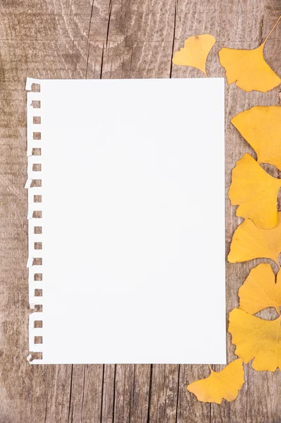 Arkusz papieru i liści jesienią na drewniane tła — Zdjęcie stockowe