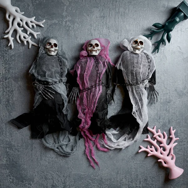 Halloween Decorazione Tre Scheletri Giocattolo Mantelli Colorati Uno Sfondo Grigio — Foto Stock