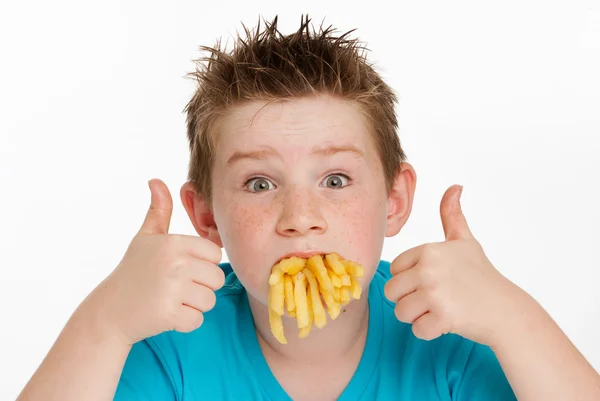 Menino comendo batatas fritas — Fotografia de Stock