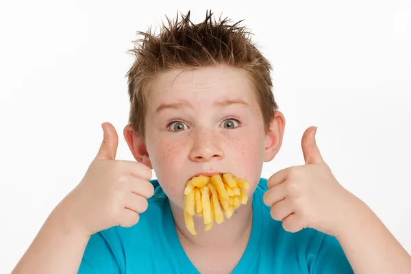 Хлопчик їсть фрі Стокове Фото