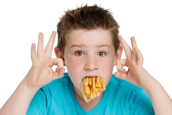 Menino com boca cheia de batatas fritas — Fotografia de Stock