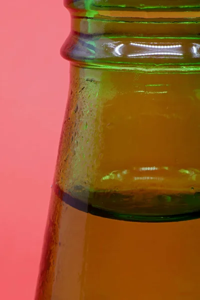 close-up bottle of mineral water with drops isolated on red background