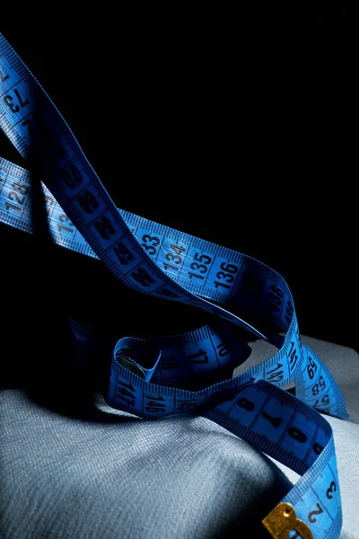blue measuring tape on a black background