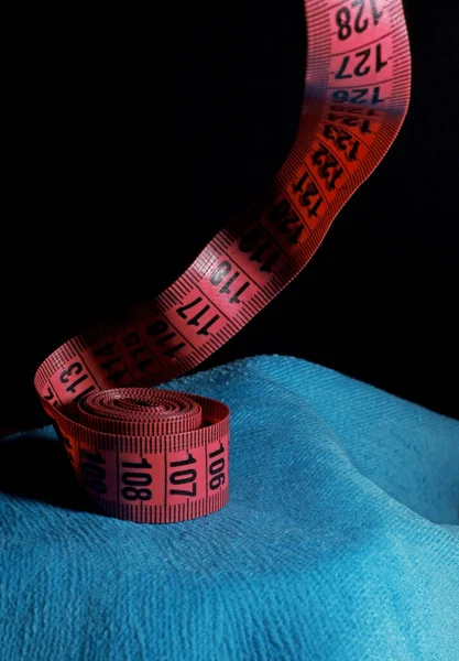 red measuring tape on a black background