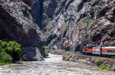 Colorado Kayalıkları, turistler için güzel ve heyecan verici bir tren yolculuğuna ev sahipliği yapıyor. Dağ geçidinin ve akan nehrin ihtişamının tadını çıkarıyorlar..