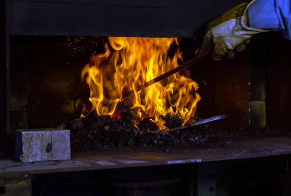 燃烧的火焰中的金属物体目前无法辨认 它很快就会变成一种独特的手工锻造的小刀 Bokeh — 图库照片