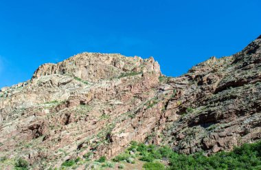 Parlak mavi gökyüzüne karşı tepe ve dokular harika bir kır manzarası oluşturur. Bir huzur ve özgürlük hissi tasvir edilir..