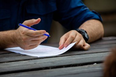 Genç erkek eller form dolduruyor. Genç adam yazıyor..