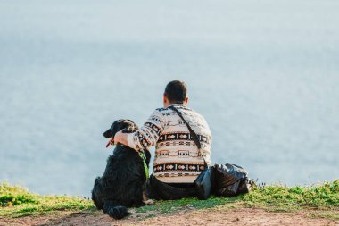 İnsanlar ve hayvanlar deniz manzarasını seyrediyor.