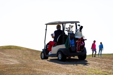 Golf arabasında bir golfçü.