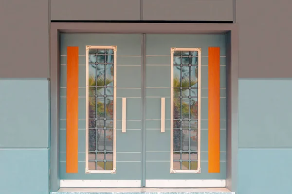 Çift yapraklı ahşap ve işlenmiş demir ev kapısı.