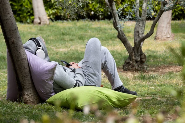 Young Man Sitting Cushion School Garden Listening Music — Φωτογραφία Αρχείου