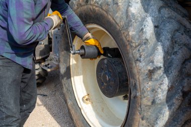 Büyük bir inşaat makinesinin lastiğini tamir ediyorum..