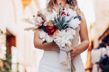 Gelin ve elinde çiçekler.