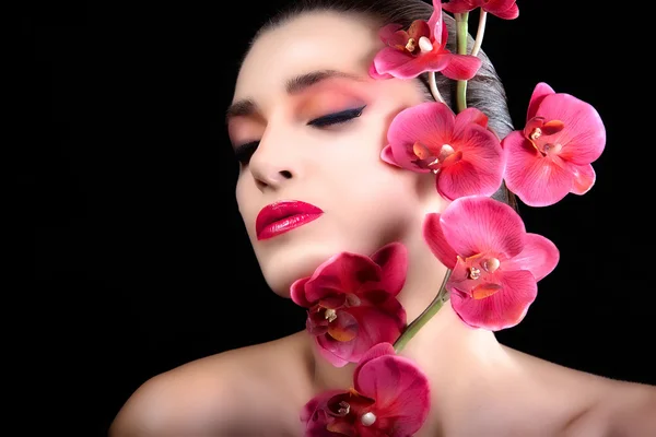 Belle fille avec des fleurs d'orchidée. Le visage. Maquillage . — Photo