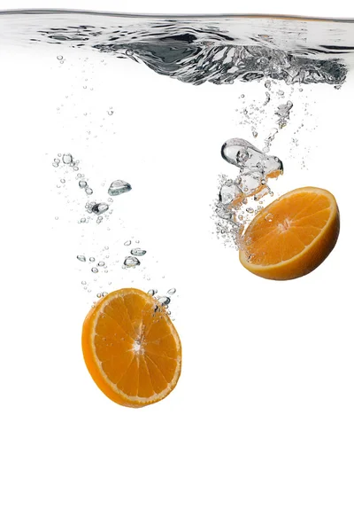 Fette di arancia sana con spruzzi d'acqua isolati su bianco — Foto Stock
