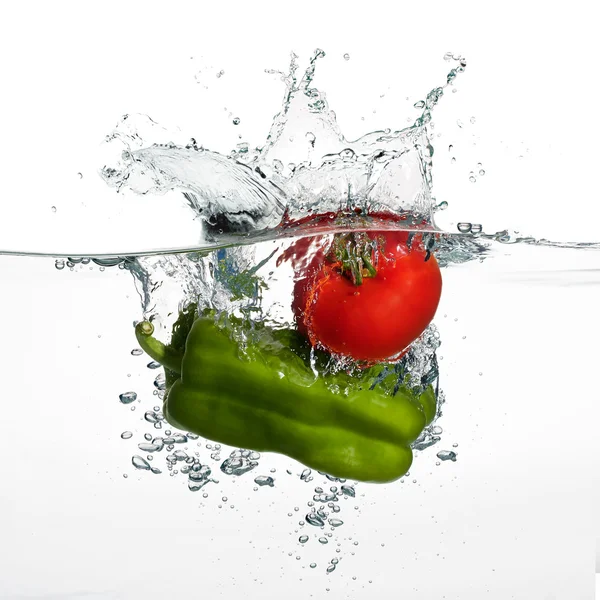 Splash de tomate e pimenta fresca em água isolada em branco Backgr — Fotografia de Stock