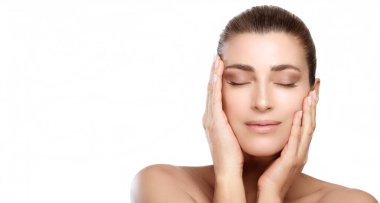Makeup and skin care concept. Beautiful brunette woman with natural makeup and glowing hydrated skin touching her face. Natural beauty with perfect healthy skin tone and fresh skin isolated on white