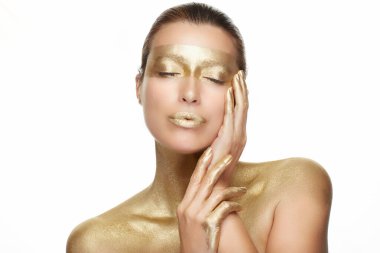 Skin care. Young woman with clean fresh skin touching her healthy facial skin. Gold skincare treatment. Beauty and Spa Cosmetology.