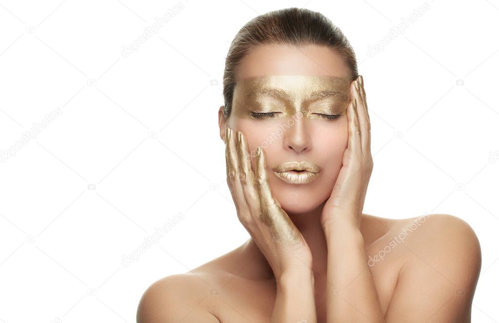 Gold based anti aging skincare concept. Beautiful model woman with gold treatment posing with closed eyes and a serene expression. Close up beauty portrait on white