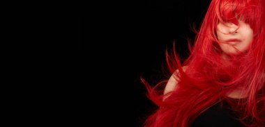 Redhead beauty model with healthy long hair isolated on black background with copy space