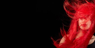 Beautiful and healthy long red hair. Flying hair isolated on black background with copy space