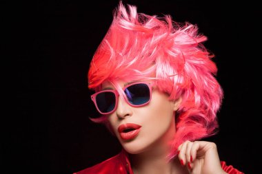 Fashion model girl with stylish dyed pink hair and sunglasses. Isolated on black background with copy space