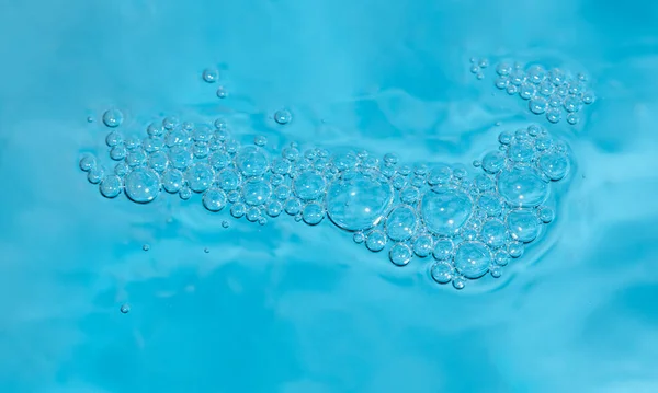 Transparent cosmetics sample texture with isolated bubbles. Blue bubbles forming background or pattern. Fresh cool blue water background with bubbles