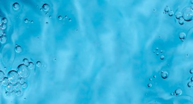 Transparent cosmetic sample texture with isolated bubbles. Blue bubbles forming on cosmetic serum gel. Hydration and skin care concept in vertical format