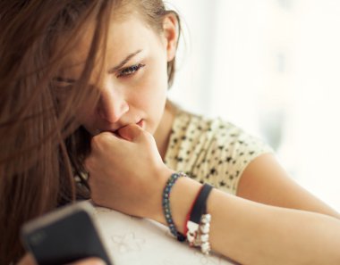 Akıllı telefonu olan genç bir kadın.