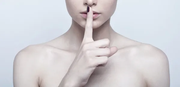 Vrouw met vinger op de lippen — Stockfoto