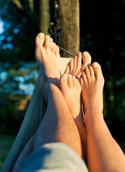 Pé de casal na rede desfrutando do sol — Fotografia de Stock
