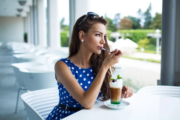 Ung kvinna vila och dricka iskallt kaffe i restaurangen — Stockfoto