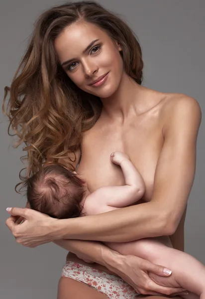 Junge Mutter füttert ihren Säugling — Stockfoto