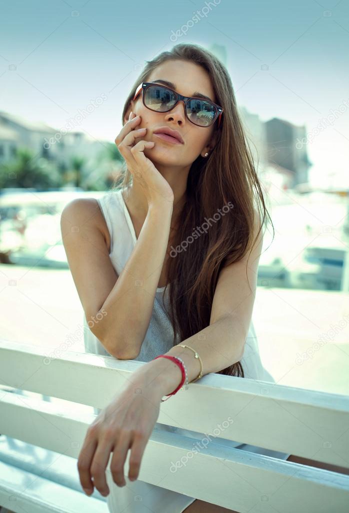 Young woman on bench wearing sunglasses