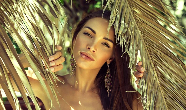 Beautiful woman between palm leaves — Stock Photo, Image