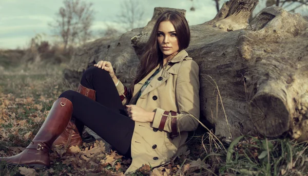 Chica joven sentada al aire libre en el paisaje de otoño — Foto de Stock