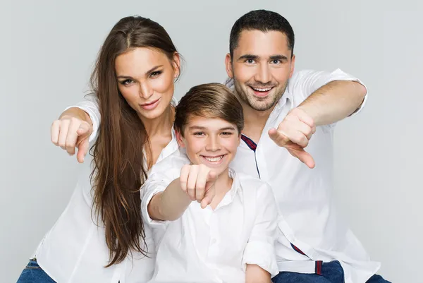 Retrato de família feliz com dedos apontantes — Fotografia de Stock