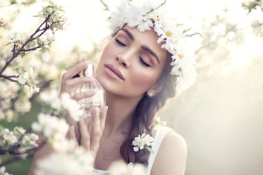 Kadın parfüm sıkıyor.