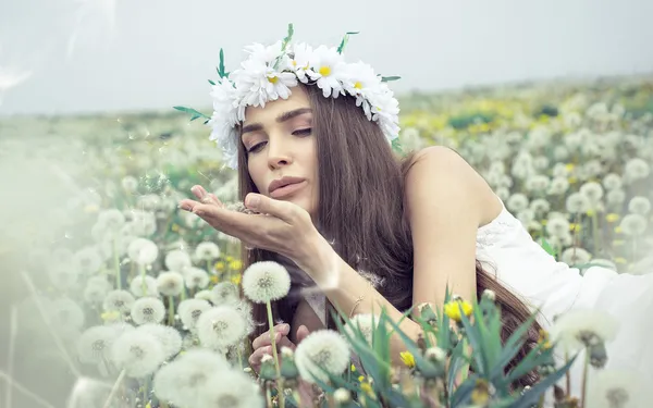 Donna che soffia denti di leone — Foto Stock