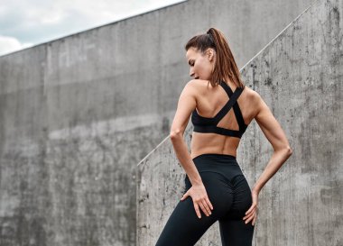 Genç bayan siyah spor takım elbise giyiyor.