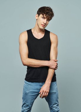 Yakışıklı adam siyah atlet giyiyor.