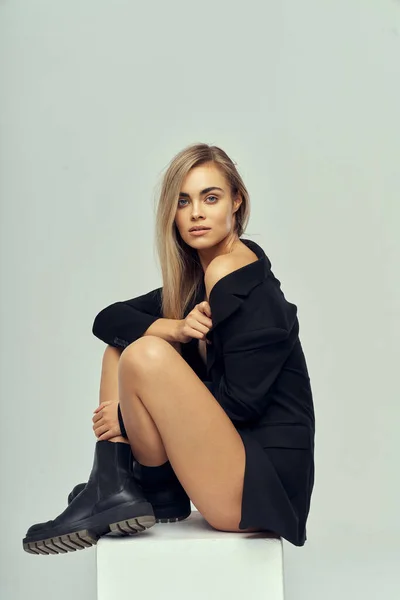 Joven Modelo Rubia Hermosa Sentado Bloque Blanco Desgaste Chaqueta Zapatos —  Fotos de Stock