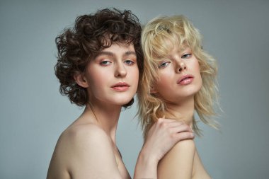 Portrait of two sensual young women with clean fresh face skin and perfect nude makeup