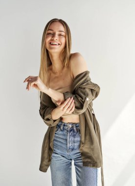 Gri arka planda gülümseyen sarışın kadın model.