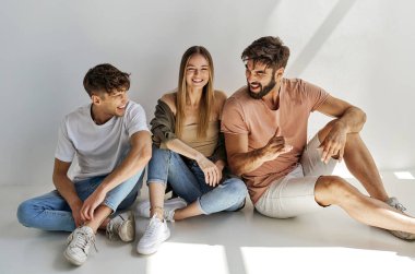 Üç arkadaştan oluşan bir grup oturup olumlu duygular ifade ediyor.
