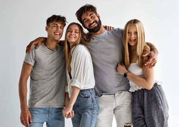 Group of best friends hugging and looking at the camera