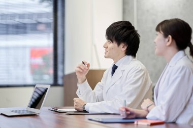 Tıbbi personel gülümseyerek toplantı yapıyor.