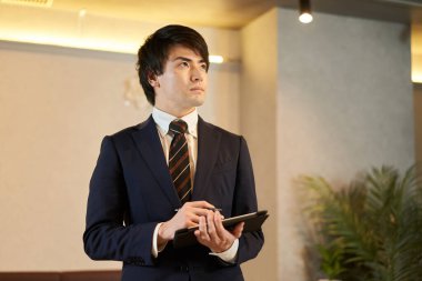 Emlak satış pozisyonunda bir adam tesisi teftiş ediyor.