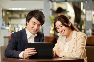 Tablet menüsünden sipariş veren Asyalı çift